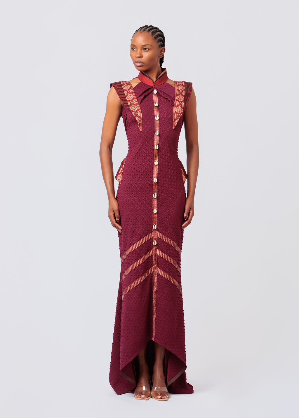 Woman wearing a Maroon dress with intricate designs on a white background