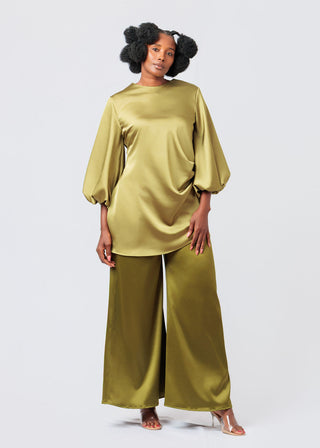 Woman wearing a green blouse outfit with wide-leg pants on a white background