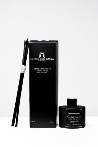 Black home fragrance collection with diffuser and packaging on a white background