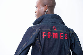 Person wearing a denim jacket with 'FAMES' printed on the back against a white background