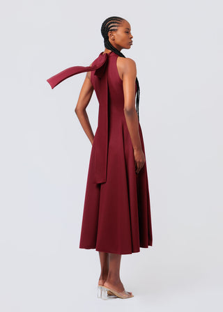 Woman wearing a knit burgundy dress with a plain background available at House of NALA.
