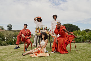 Group of people in Luxury occasion wear sitting outdoors with a scenic background. 