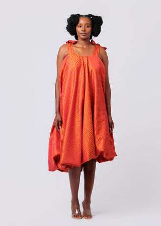 Woman wearing an orange dress against a white background