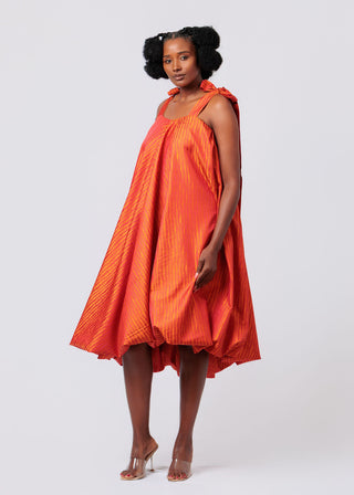 Woman wearing an orange dress on a white background