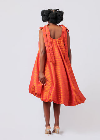 Person wearing an orange dress with a white background
