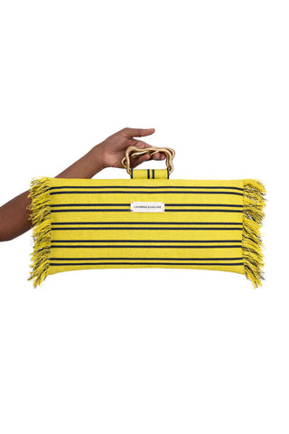 Yellow striped clutch held by a hand on a white background available at House of NALA.