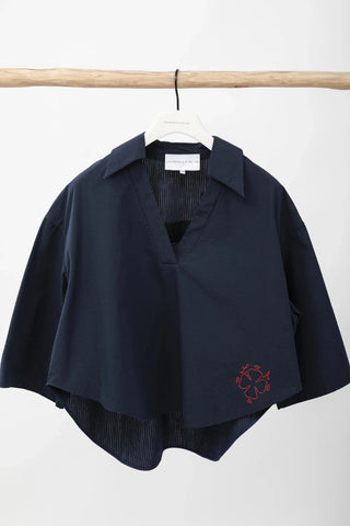 Navy blue mens top with a red emblem on a white background