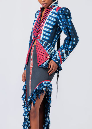 Person wearing a colorful patterned outfit with a high slit on a light gray background