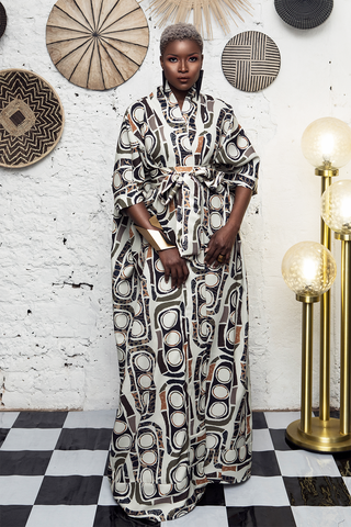 Woman in a patterned dress standing in a room with decorative wall art and a checkered floor sold at House of NALA
