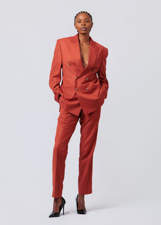 Person wearing a orange suit on a light gray background