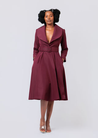 Woman wearing a burgundy trench coat on a white background