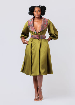 Woman wearing a green dress with a patterned jacket on a white background