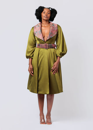 Woman wearing a olive green dress with brocade collar and belt on a white background