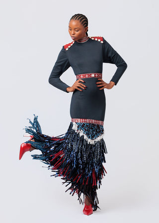 Woman wearing a black dress with red and blue fringe details on a white background available at House of NALA