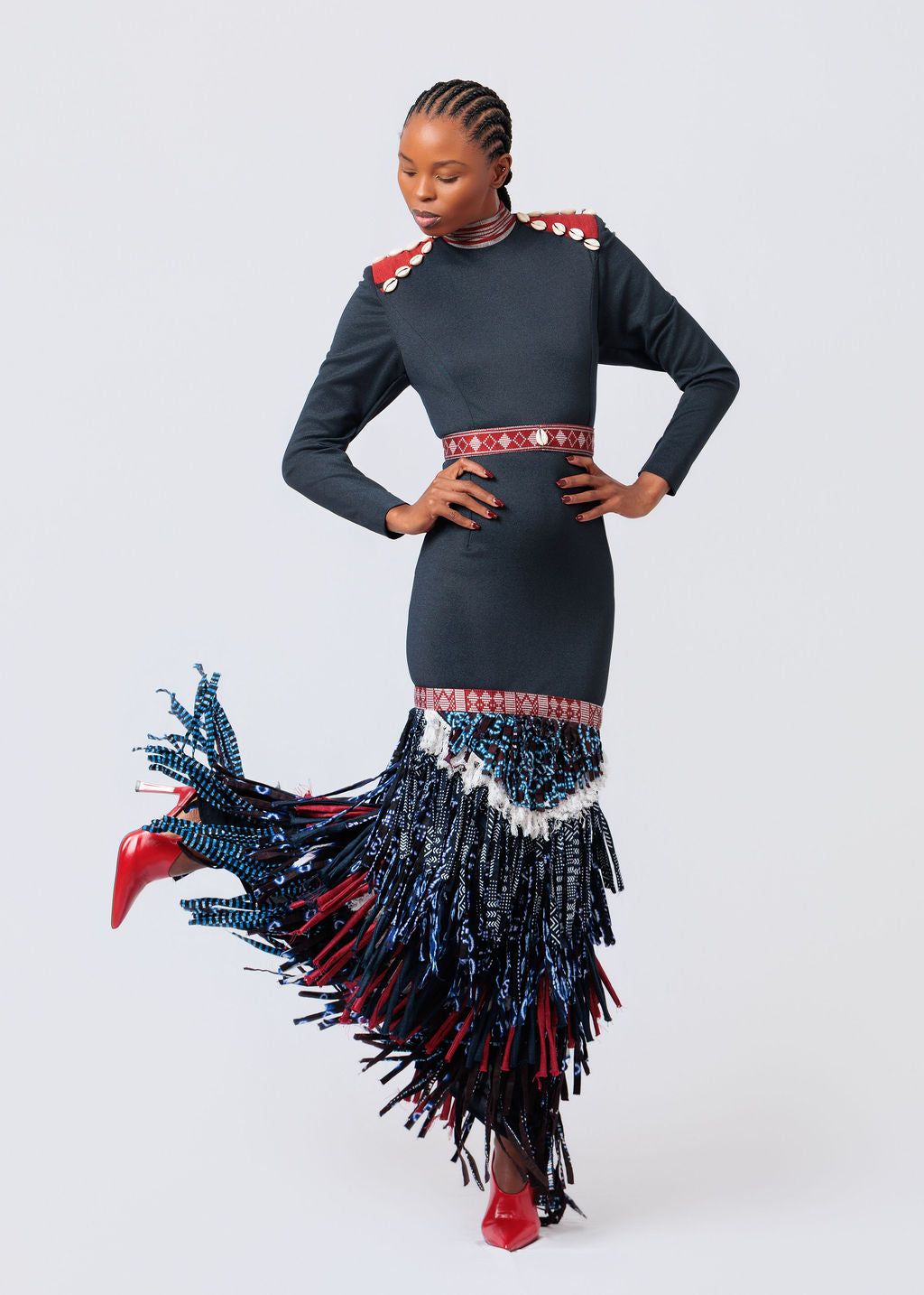 Woman wearing a black dress with red and blue fringe details on a white background available at House of NALA