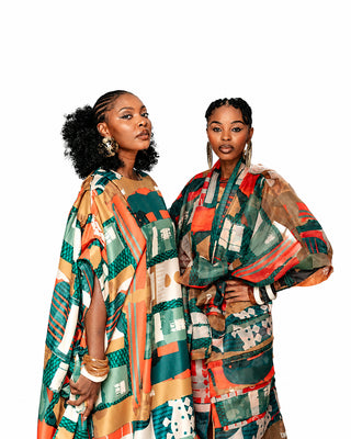 Two women wearing colorful patterned outfits on a white background
