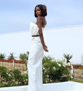 Side profile of a white column dress showcasing its structured bodice and elegant strapless style