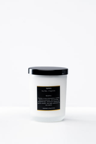 White candle with a black lid and label on a white background