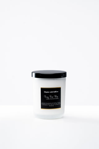 White candle with a black lid and label on a white background