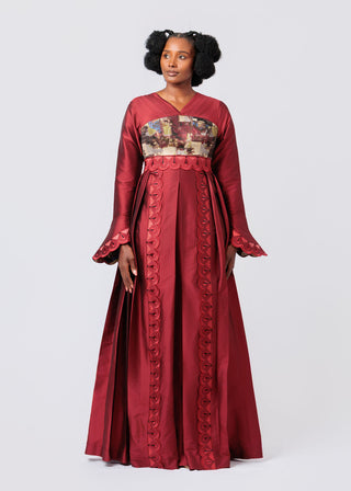 Woman wearing a red maxi dress with floral embroidery on a white background