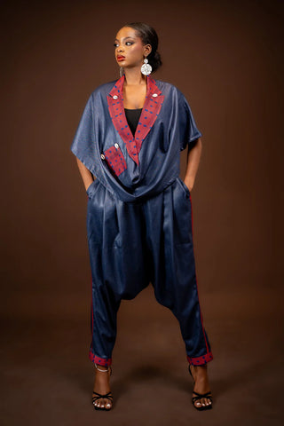Woman wearing a blue jumpsuit with red accents against a brown background