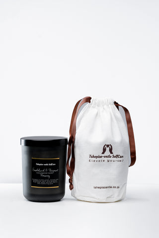 Black candle and white drawstring bag with branding on a white background