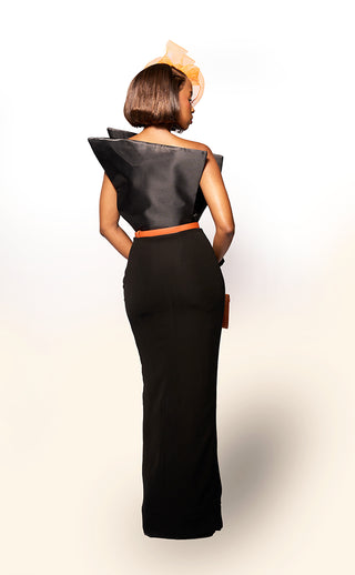 Woman wearing a black evening gown with a fitted bodice and flowing skirt on a white background