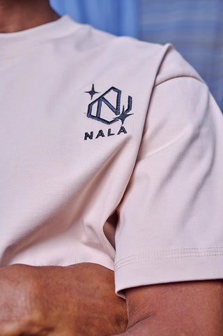 Beige t-shirt with NALA logo on a person wearing it.
